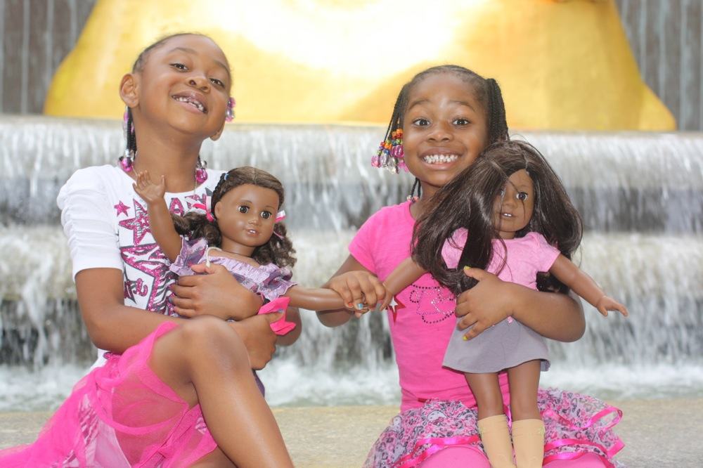 Two little black girls with their American Girl Dolls