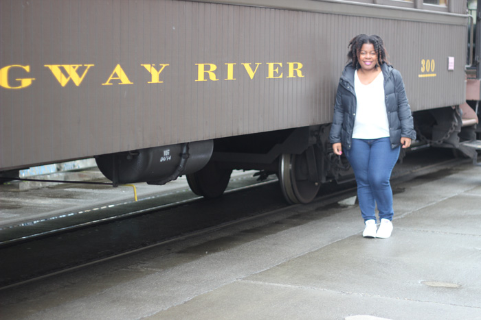 Black girl next to a train.